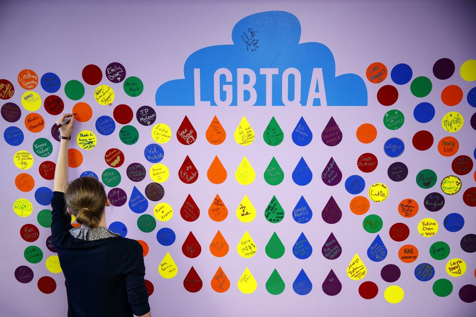 a student faces a wall of colorful circle stickers
