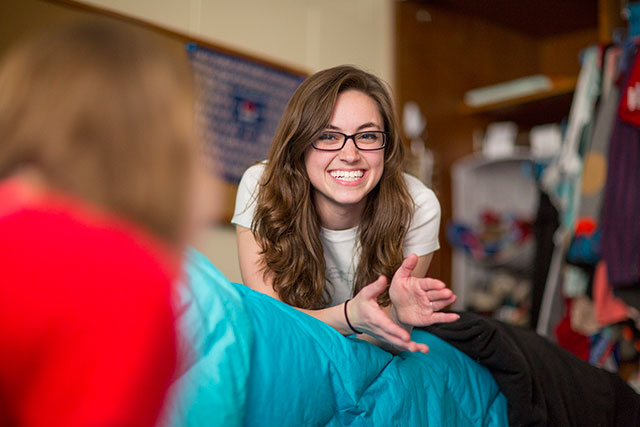 Student smiling in Res hall room