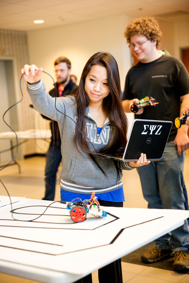 A student guiding a robot through a course