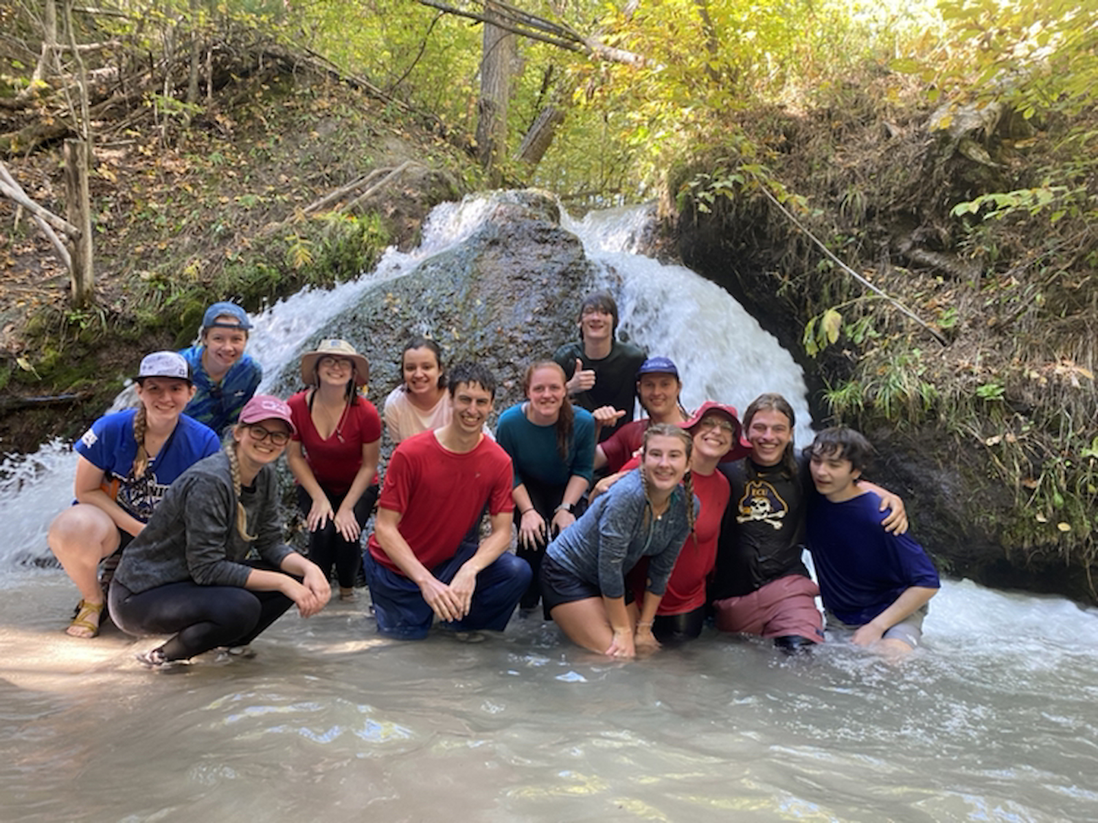 Nature Explorers students posing in a river