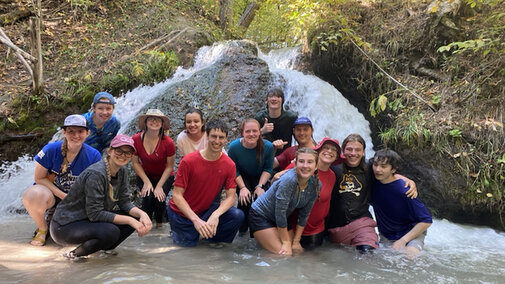 Nature Explorers students posing in a river