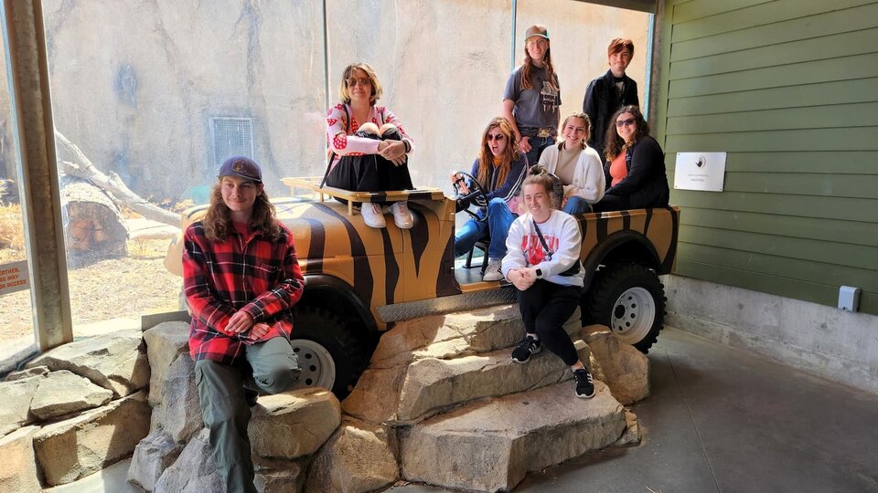 Students posing in a display Jeep at the Lincoln Children's Zoo