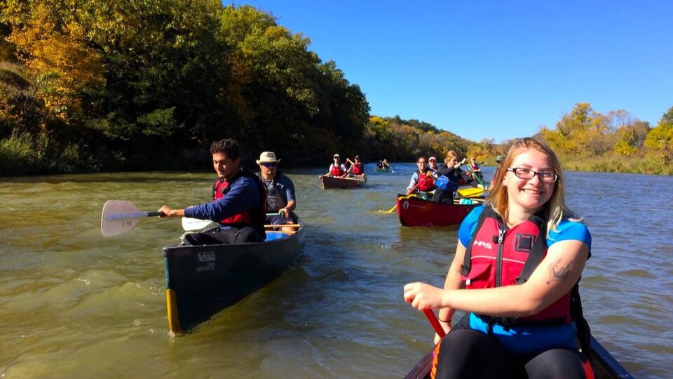 Student canoeing down a river