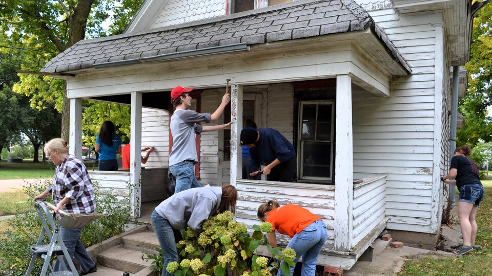 Students providing maintenance to a home for a community service project